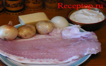 на большом блюде филе морского языка, две сырых картофелины, две луковицы, кусочек сыра, рядом миска с сметаной