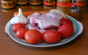 на большом блюде лежат порционные куски курицы, шесть помидоров, чеснок, лук, морковь