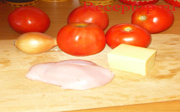начало рецепта: на разделочной доске лежит два помидора, куриное филе, одна небольшая луковица и кусок сыра